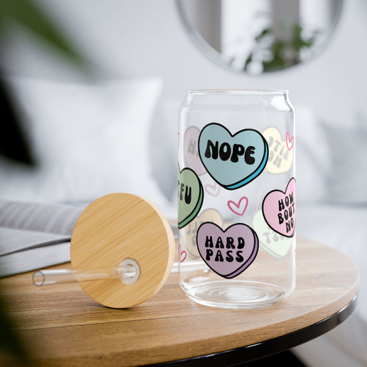 Clear glass with colorful heart-shaped text on a wooden table, anti valentines candy heart messages