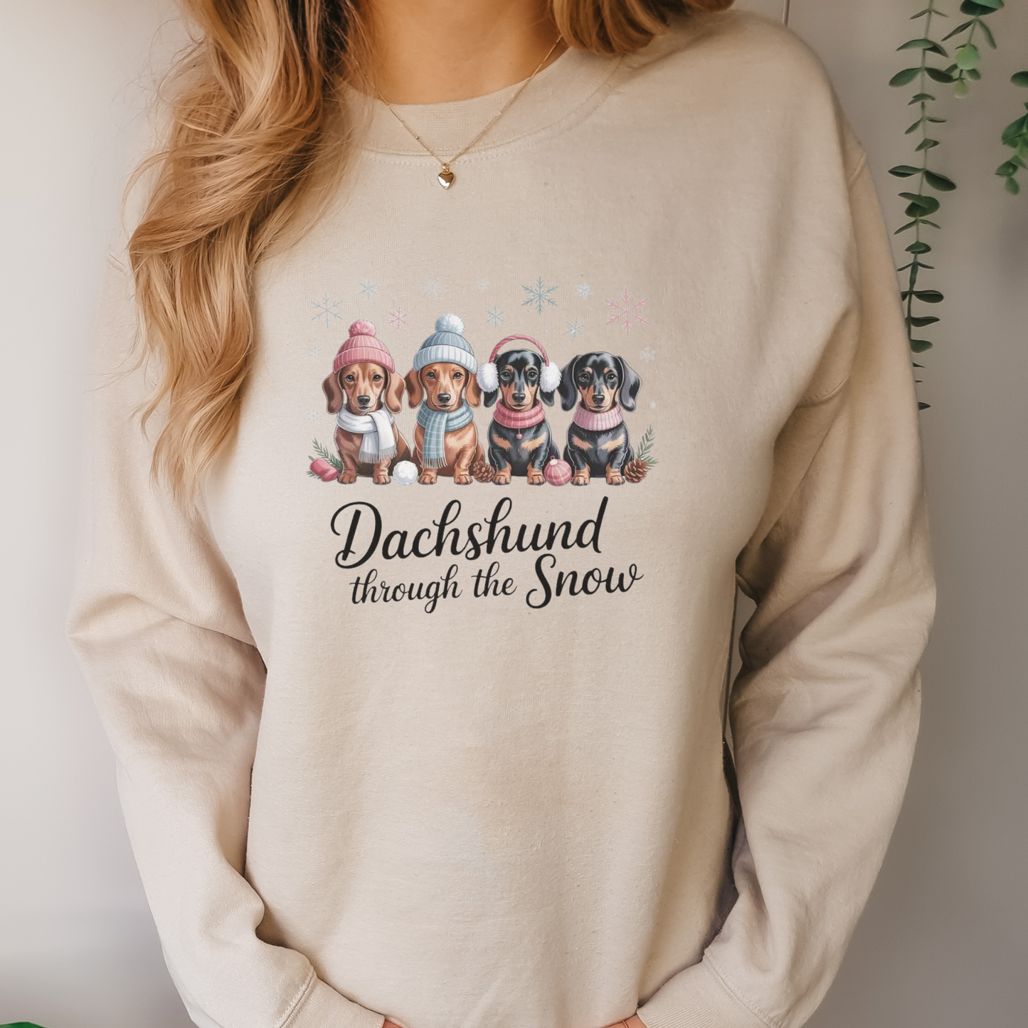 Beige sweatshirt with dachshund design and text 'Dachshund through the Snow'