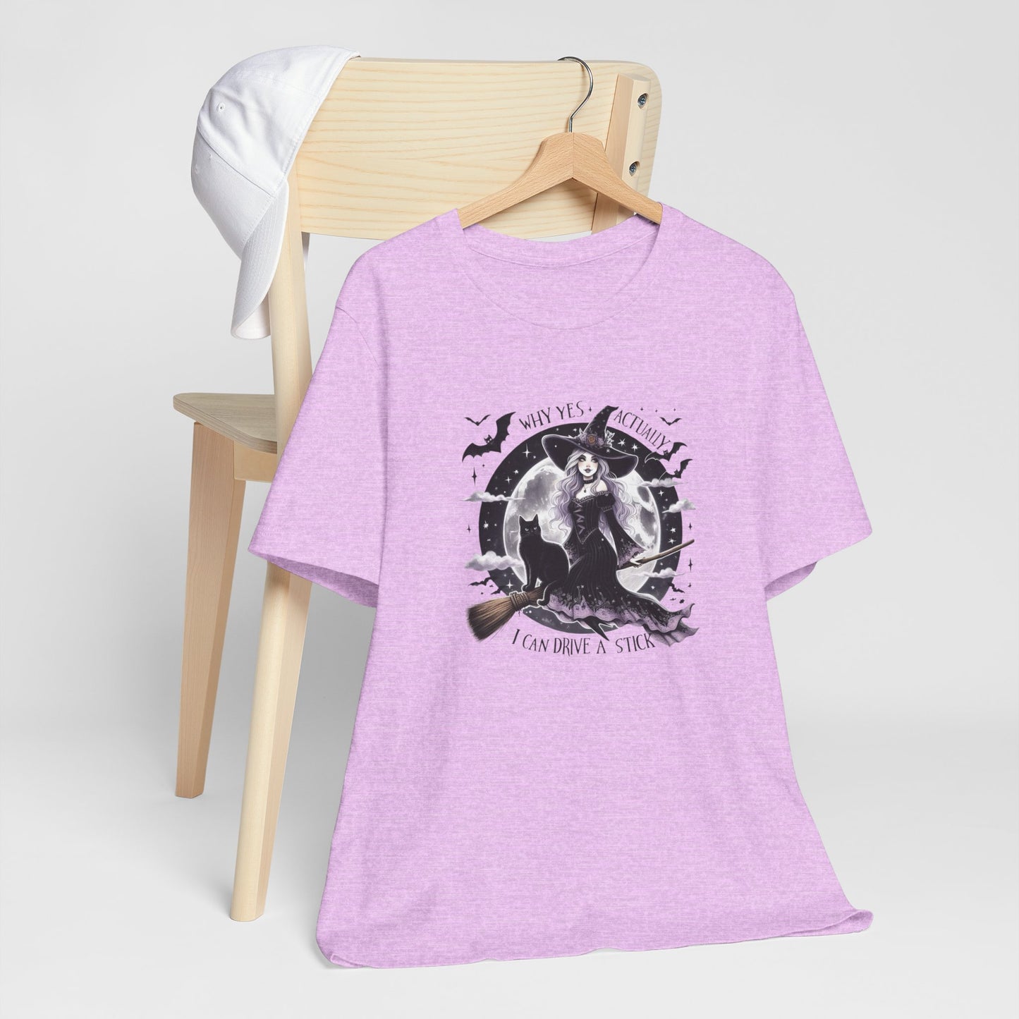 heather prism lilac t-shirt with graphic design on a wooden chair against a white background, why yes actually, i can drive a stick, halloween tee