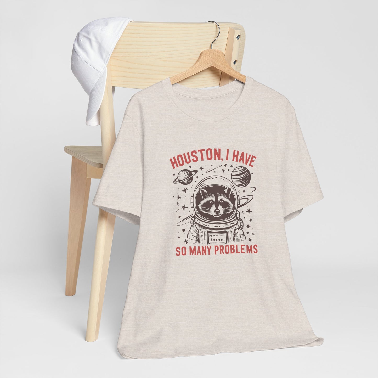 Beige t-shirt with a graphic design and text on a white background, houston i have so many problems