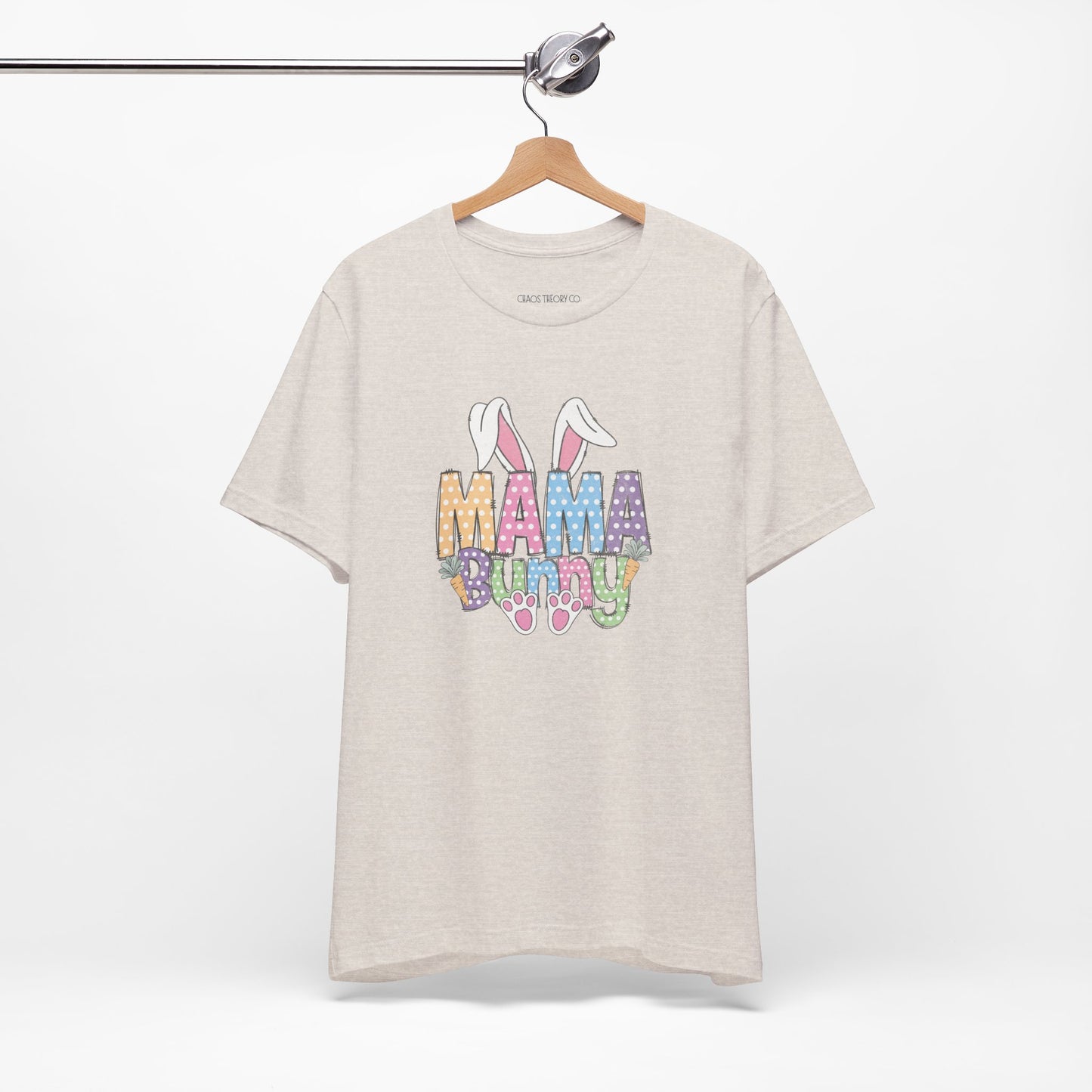 Beige t-shirt with 'Mama Bunny' graphic on a hanger against a white background