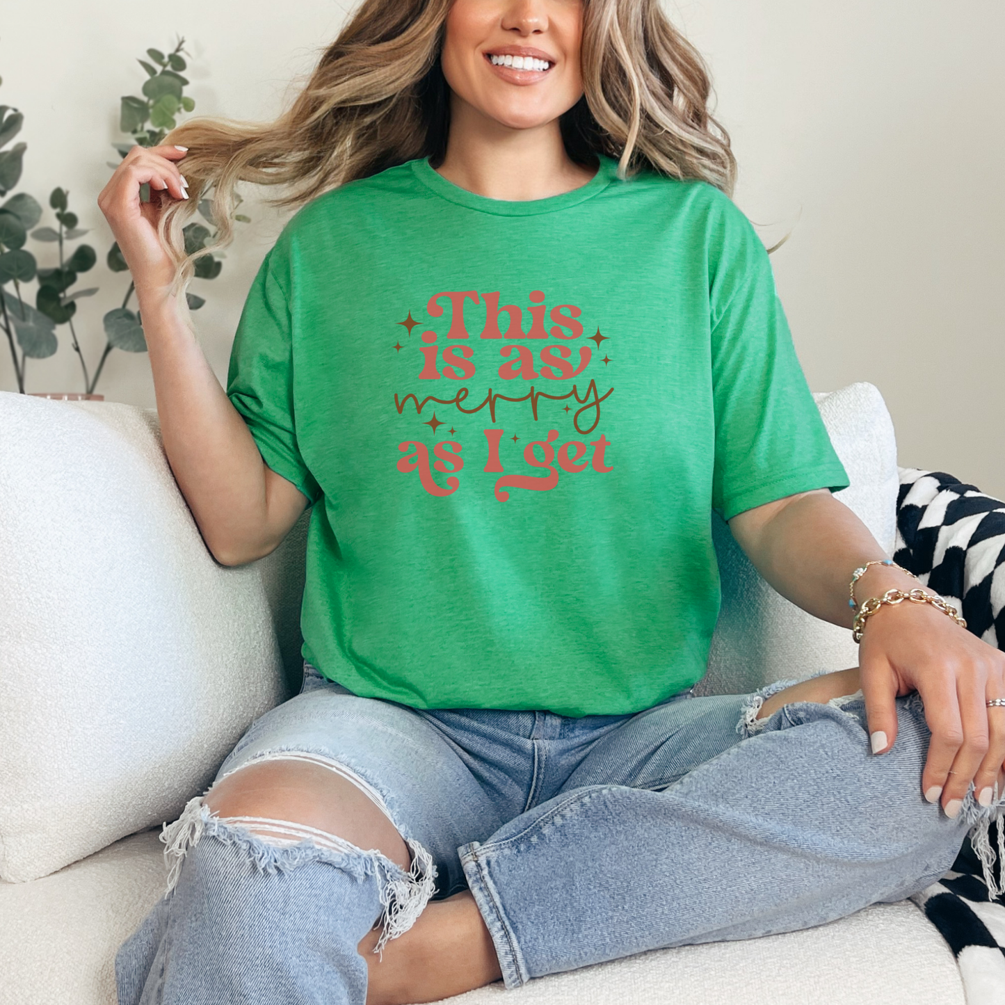 Person wearing a green t-shirt with red text sitting on a couch.merry as i get