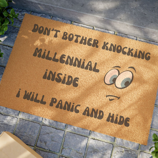 Doormat with humorous text and cartoon eyes on a stone floor. don't bother knocking, millennial inside i will panic and hide