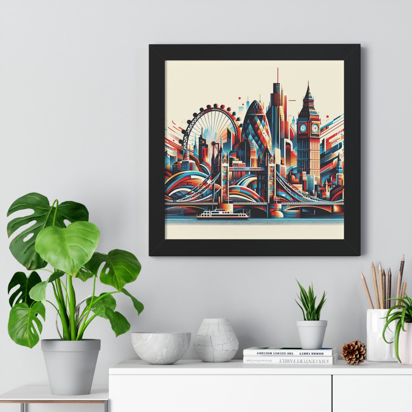 Framed artwork of a stylized cityscape on a wall above a white cabinet with decorative items. new york city