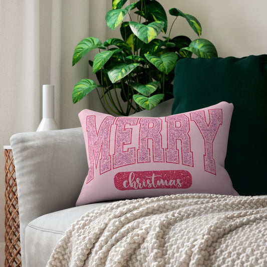 Pink 'Merry Christmas' pillow on a couch with a plant in the background